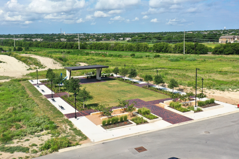 Central green space at Kyle Crossing in Kyle, Texas, featuring landscaped park area, walkways, and gathering space constructed by Synergy Commercial Construction