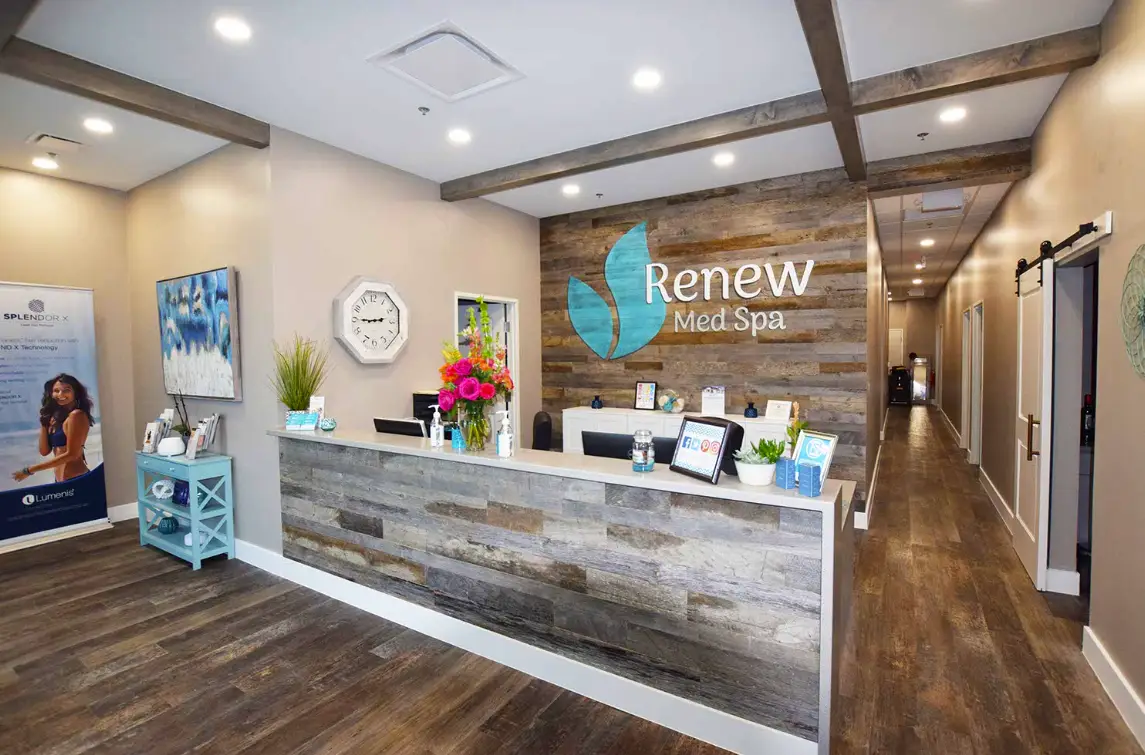 Renew Med Spa reception area with branded feature wall and front desk built by Synergy Commercial Construction as part of tenant improvement project