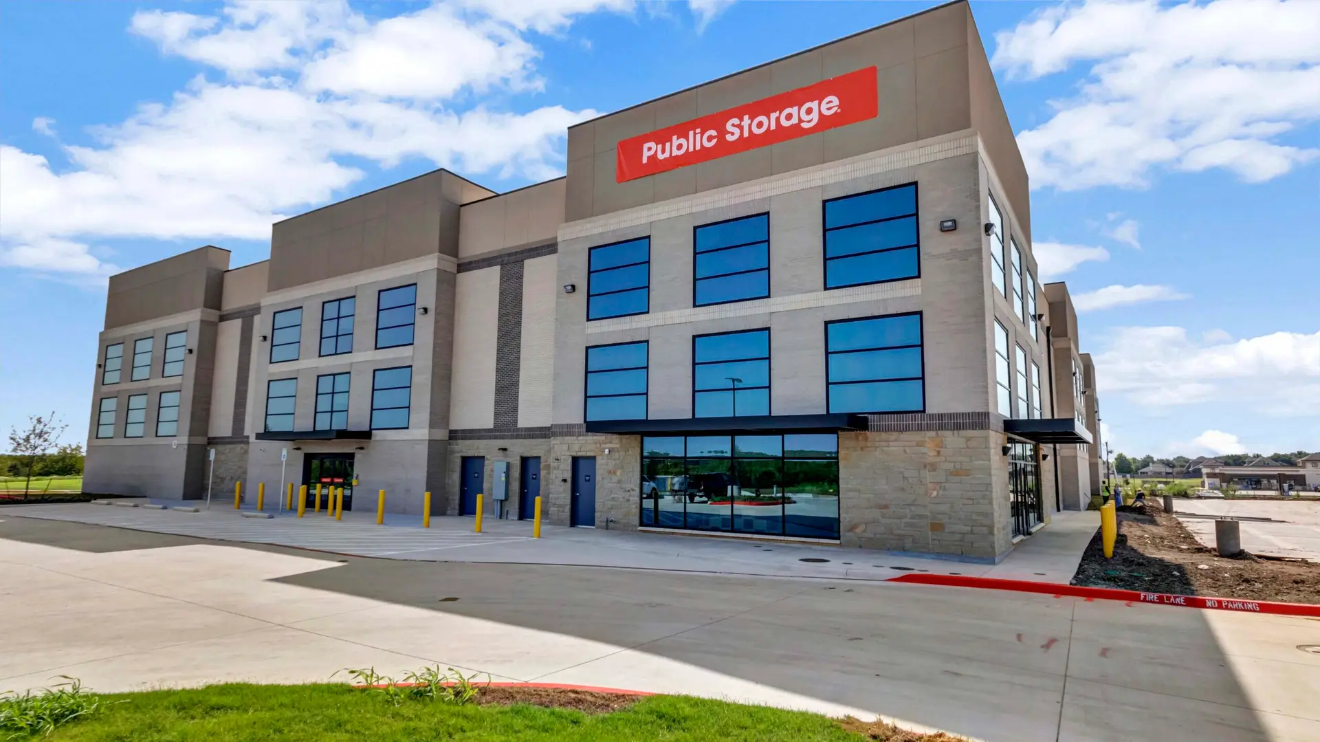 Exterior view of the three-story Public Storage Sachse facility showing the completed building façade, storefront glazing, and site improvements completed by Synergy Commercial Construction.